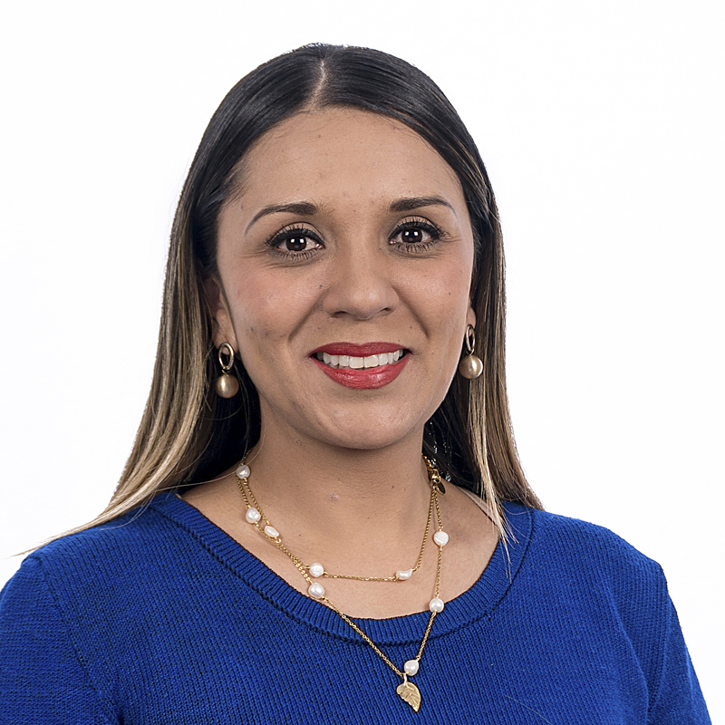 Mujer con suéter azul y collar de perlas, sonriendo. foto profesional para perfil corporativo. Foto de mujer con cabello largo y maquillaje natural - LaCardio - Diana Carolina Ramos Martinez